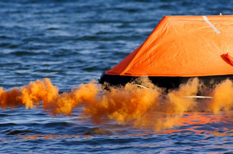 Deployed life raft with buoyant smoke in front