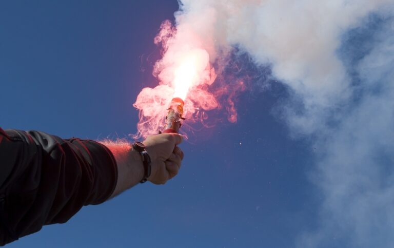 Activated marine red hand flare being held